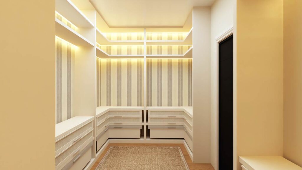 Walk-in closet with U-shaped built-in cabinetry, open shelving, and accent lighting.