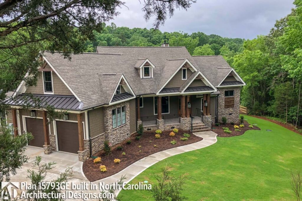 House plan exterior with stacked stone accents, a covered front porch with timber columns, multiple gables, and a three-car garage.