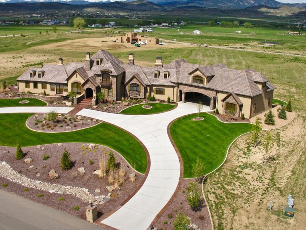 House plan exterior with a sweeping driveway, a porte-cochere, multiple gables, and dormer windows.